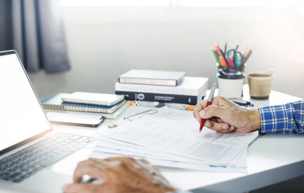 Documentos de laudo técnico de engenharia civil sobre a mesa, com planos de construção ao fundo, ilustrando o processo meticuloso de avaliação para garantir a integridade e conformidade de projetos arquitetônicos